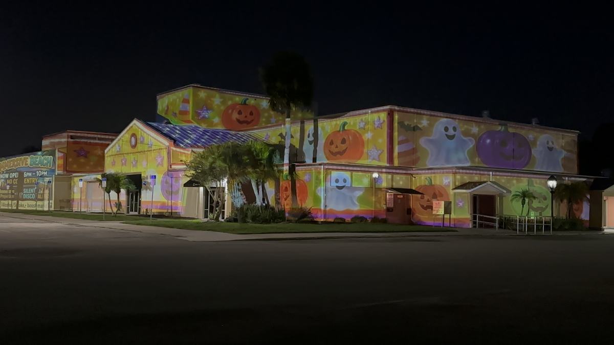Cartoon ghosts and pumpkins projected on a building