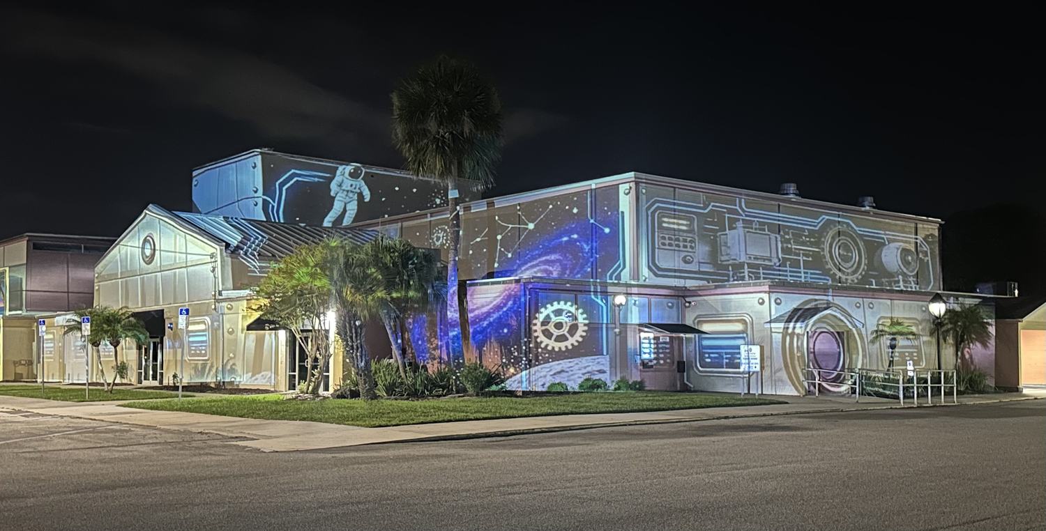 Space themed projection with an astronaut and galaxy across a building